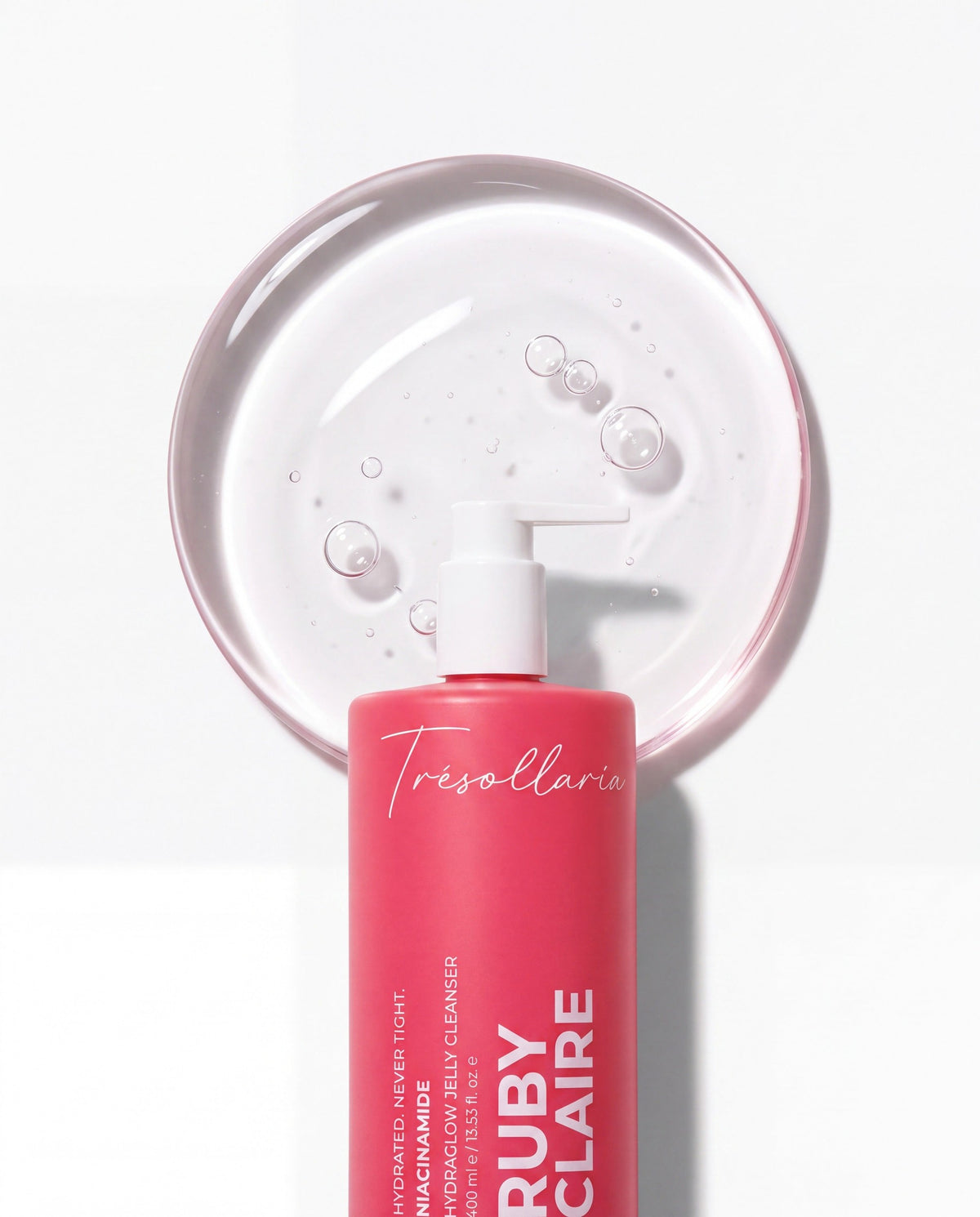 HydraGlow Jelly Cleanser bottle beside a glass disk of clear jelly texture