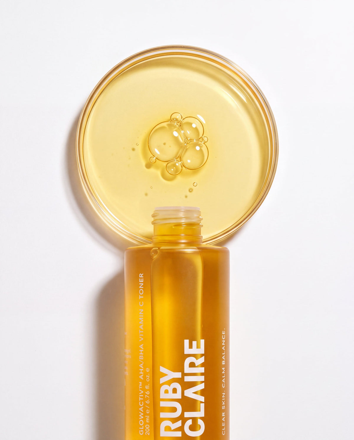 Ruby Claire GlowActiv toner texture disc above the open bottle