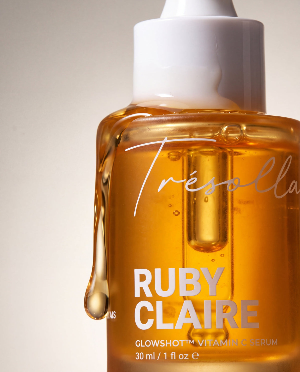 Ruby Claire GlowShot Vitamin C Serum bottle with amber serum running over the cap
