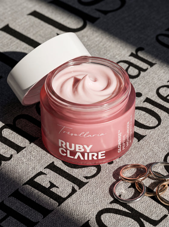 Ruby Claire GlowRise Peptide Moisturizer open jar on a magazine with rings