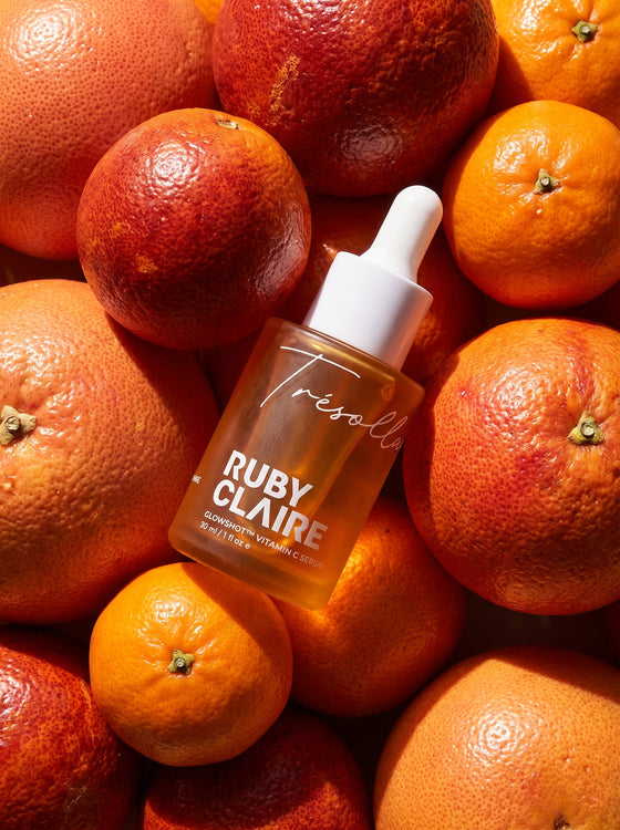 Ruby Claire GlowShot Vitamin C Serum resting on blood oranges
